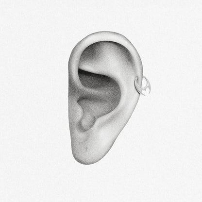 Silver Crescent Resolve Clicker shown on ear placement with sculptural crescent detail