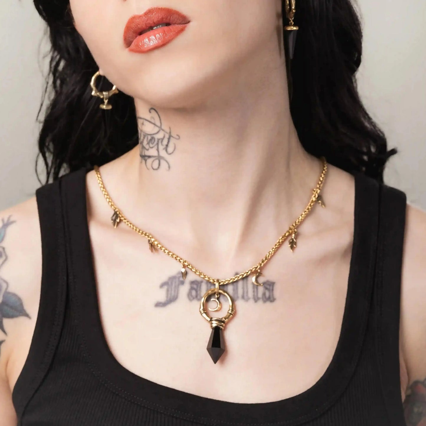 Gold Crescent Ward Necklace styled on model with moon ring pendant and dark stone accent