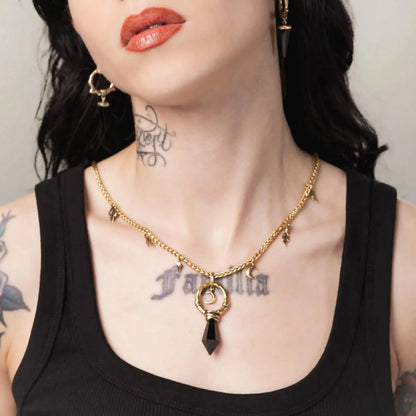 Gold Crescent Ward Necklace styled on model with moon ring pendant and dark stone accent