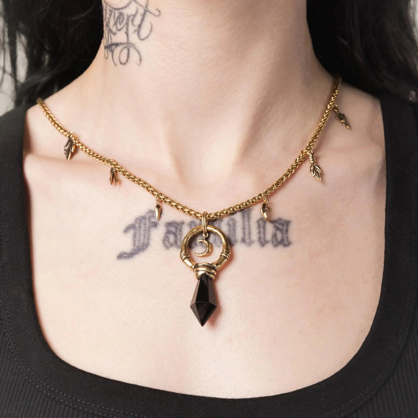 Model wearing the gold Crescent Ward Necklace with black obsidian spike pendant and antiqued chain