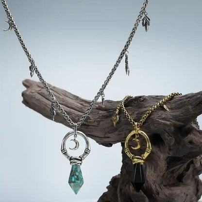 Crescent Ward Necklace in gold and silver displayed on weathered wood with moon and stone pendant details