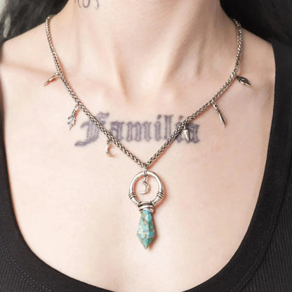 Model wearing the silver Crescent Ward Necklace with turquoise spike pendant and moon charm design