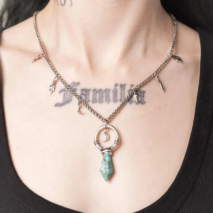 Model wearing the silver Crescent Ward Necklace with turquoise spike pendant and moon charm design