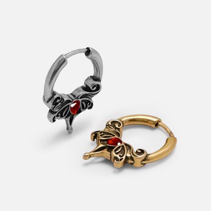 Silver-tone and gold-tone Crimson Wing earrings shown at an angle with red teardrop stones
