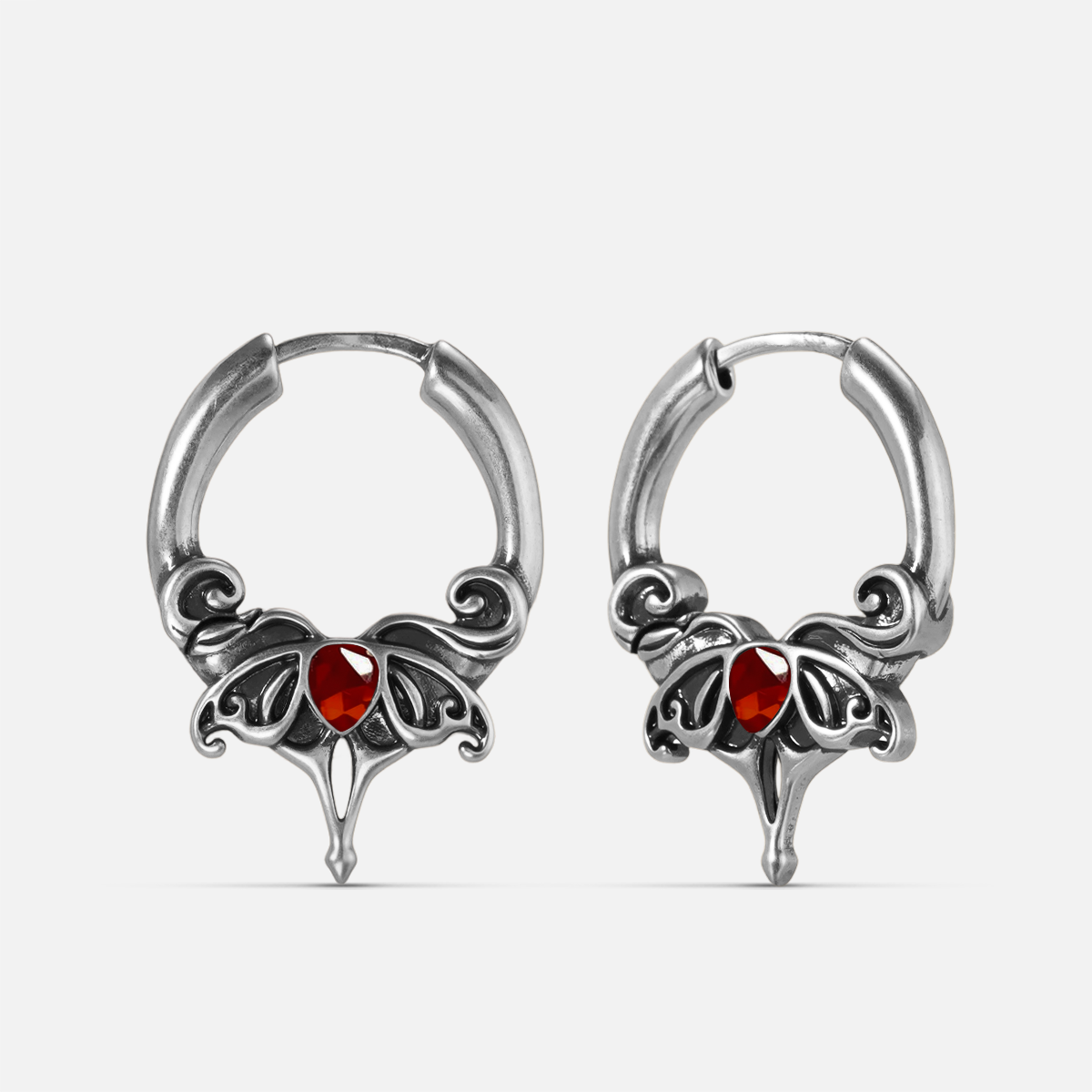 Silver-tone Crimson Wing hoop earrings with red teardrop stones, scrolling wings, and pointed drops
