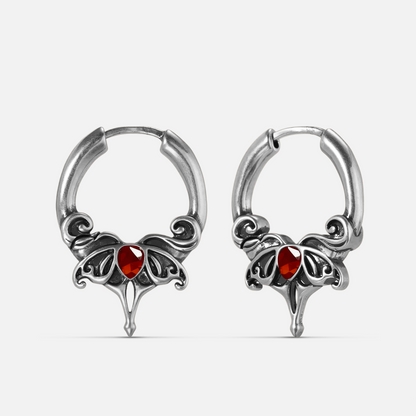 Silver-tone Crimson Wing hoop earrings with red teardrop stones, scrolling wings, and pointed drops