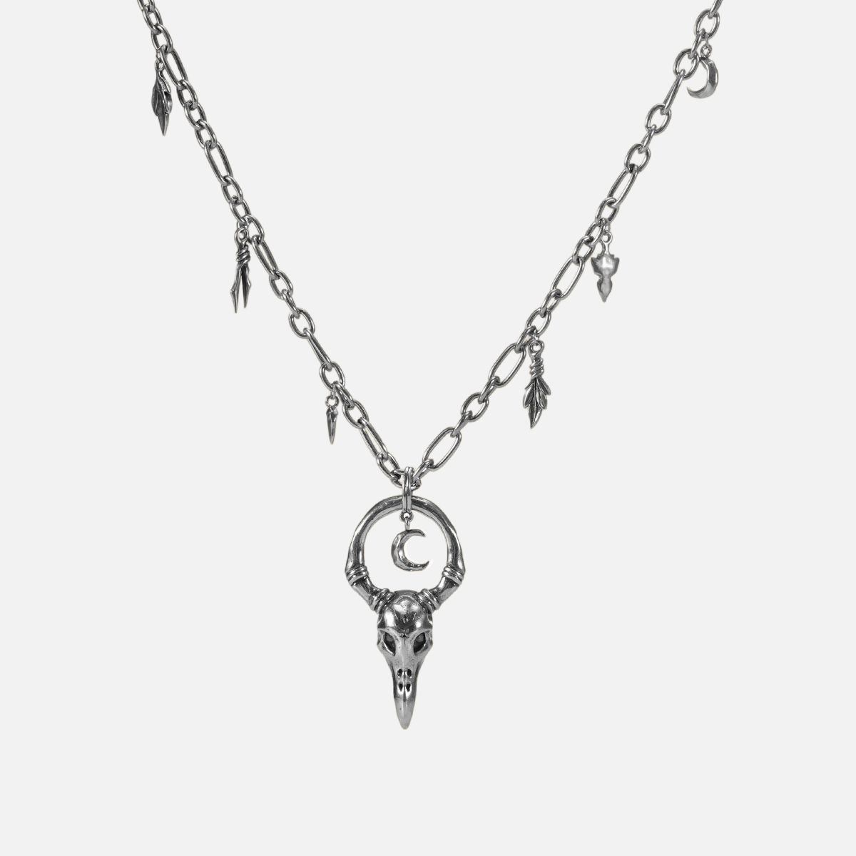 Crow Ward Necklace in silver plating with bird skull pendant, crescent moon detail, and antiqued finish