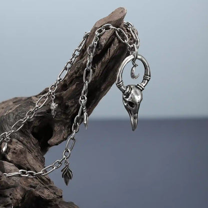 Silver Crow Ward Necklace displayed on weathered wood with dark woodland relic styling