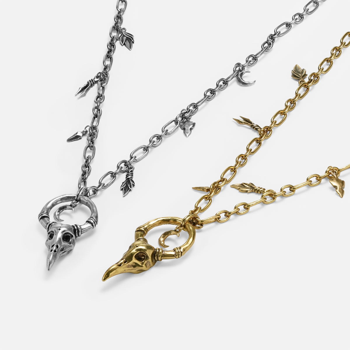 Crow Ward Necklace shown in silver and 18K gold plating with antiqued bird skull pendant