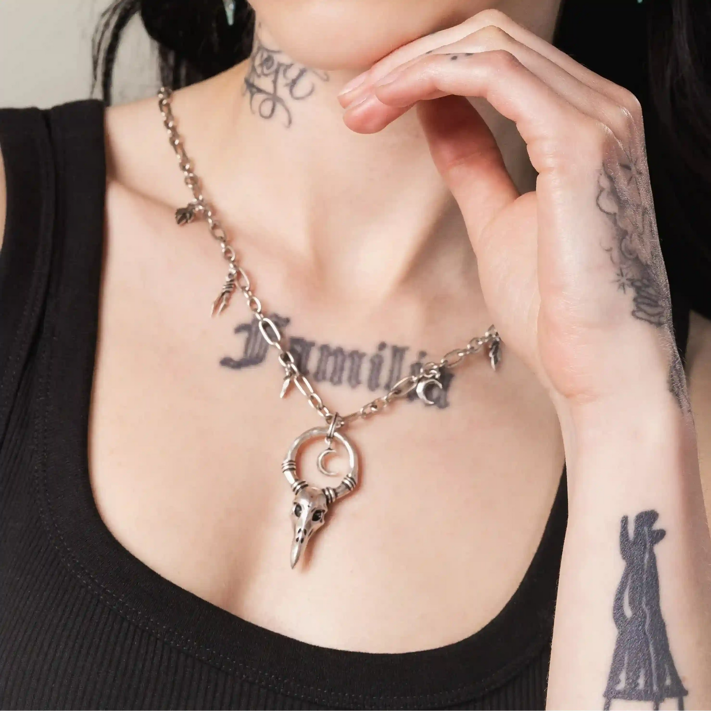 Silver Crow Ward Necklace styled on model with crescent moon and crow skull pendant design