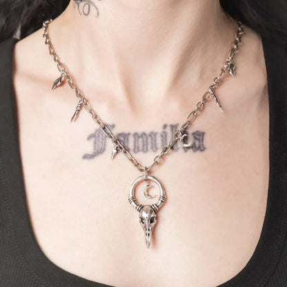 Model wearing the silver Crow Ward Necklace with bird skull pendant and charm chain