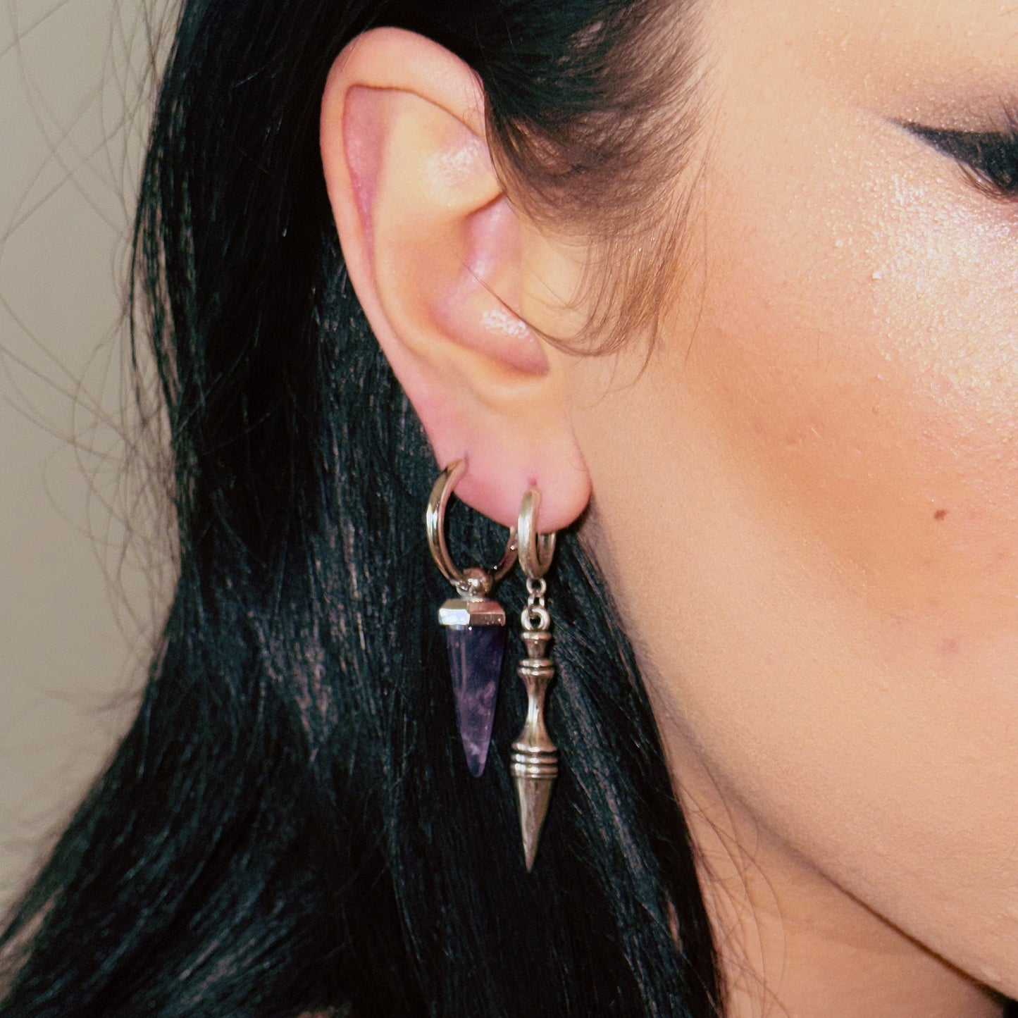 Silver-tone Crystal Prismatic hoop earring worn in a layered ear look with a second pointed drop
