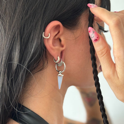 Silver-tone Crystal Prismatic hoop earring with an iridescent point worn in a layered ear look