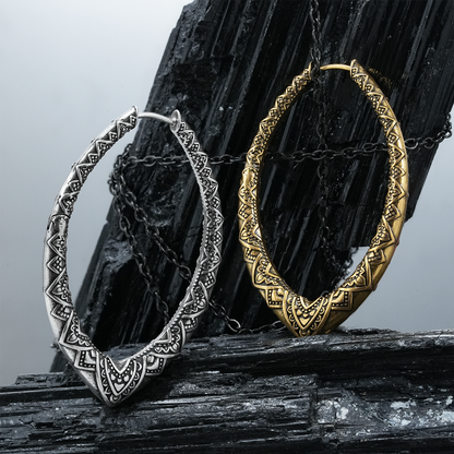 Silver and gold Cultural Essence hoop earrings displayed on black crystal