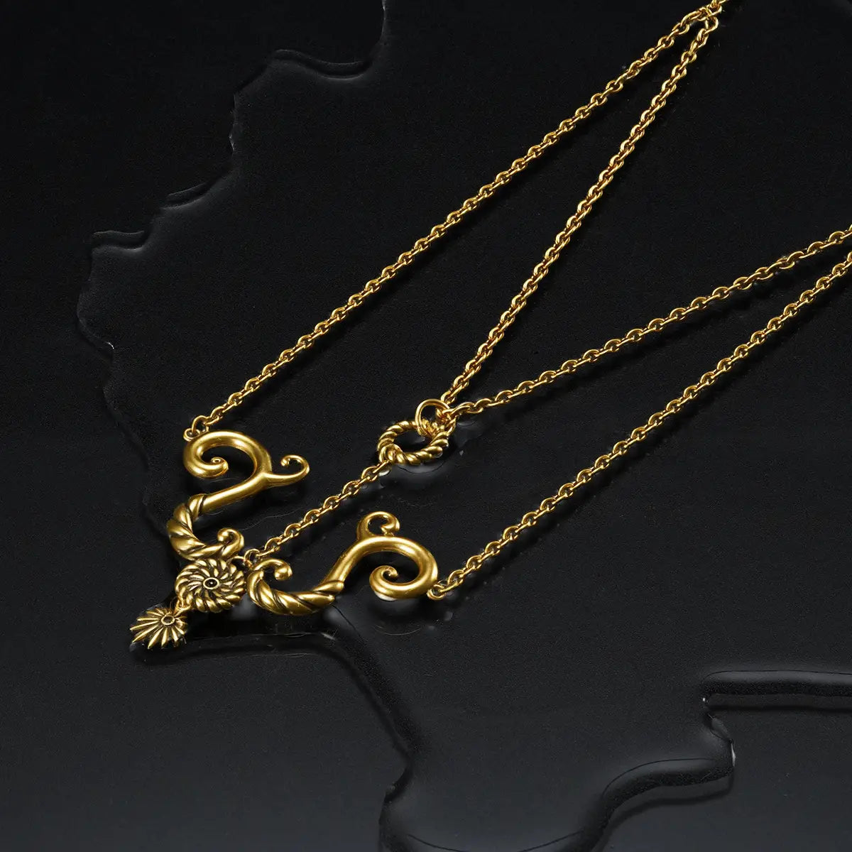 Dark coastal jewelry style gold brass tide knot necklace on textured black water surface