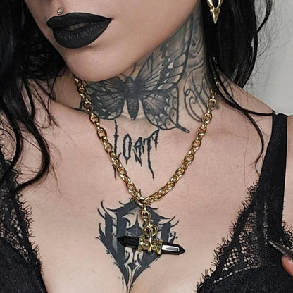 Model wearing the gold Dual Prism Necklace with a horizontal black crystal pendant, layered gothic jewelry, and dark alternative styling.