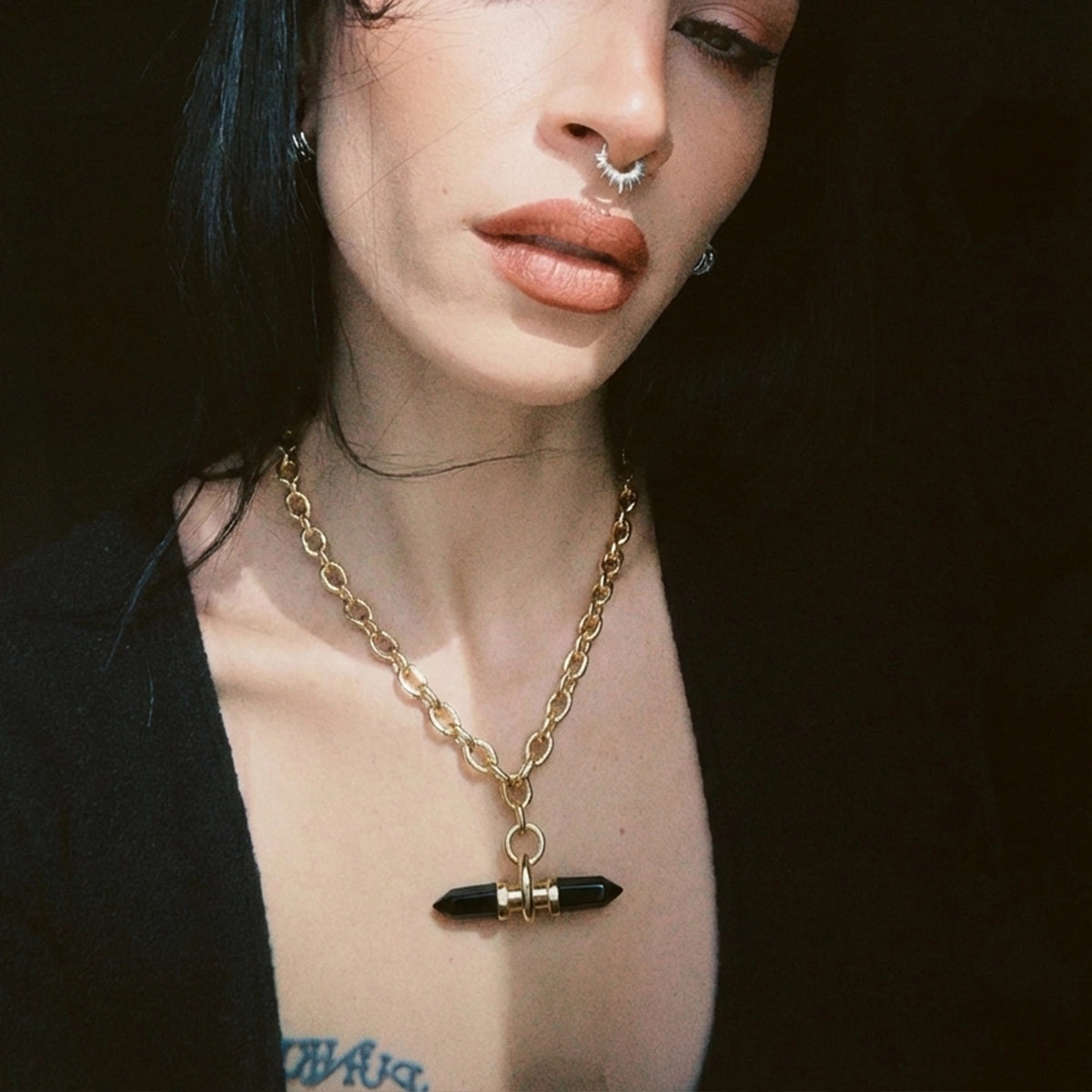 Model wearing a gold Dual Prism necklace with black horizontal pendant