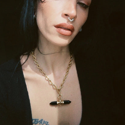 Model wearing a gold Dual Prism necklace with black horizontal pendant