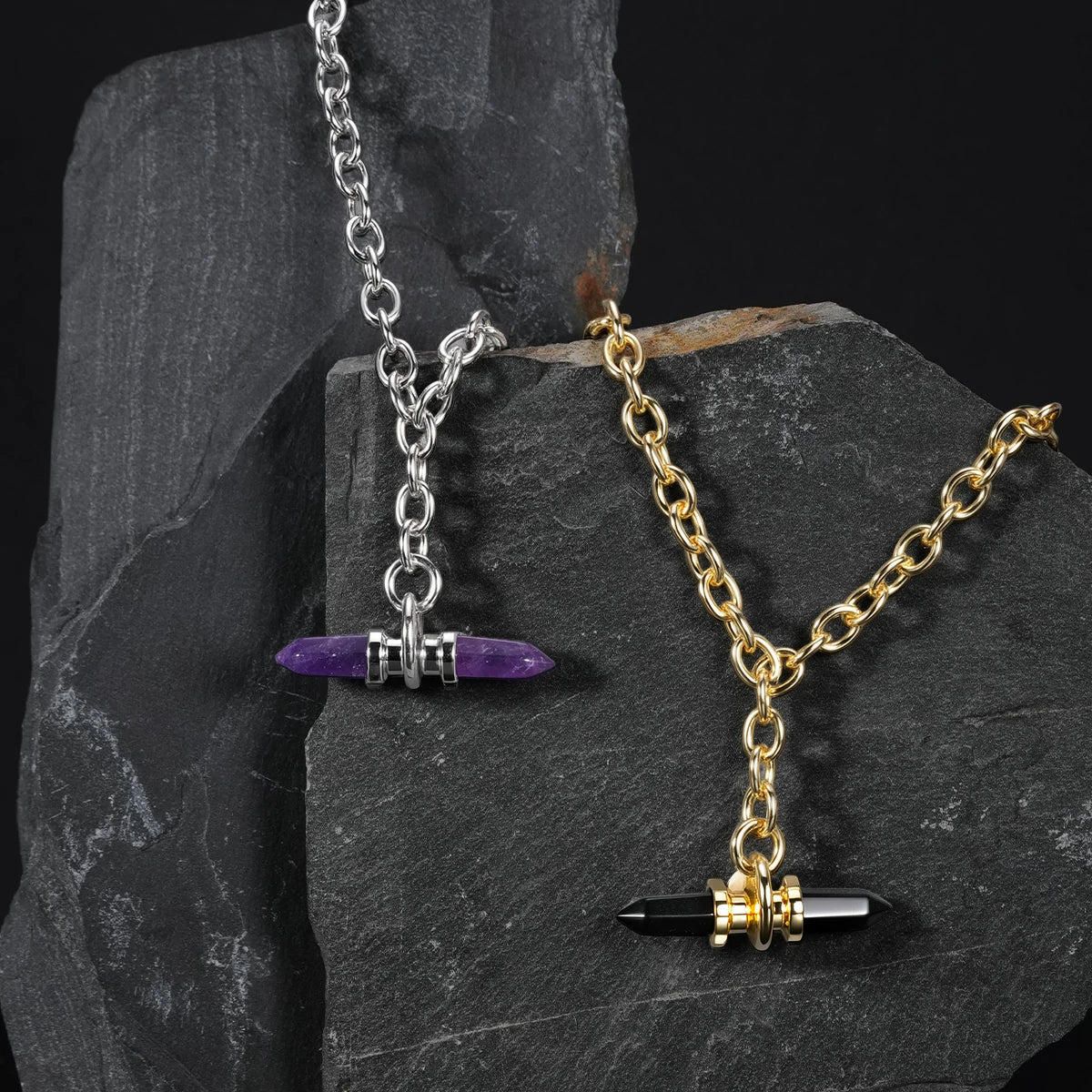 Silver and gold Dual Prism necklaces displayed on dark stone