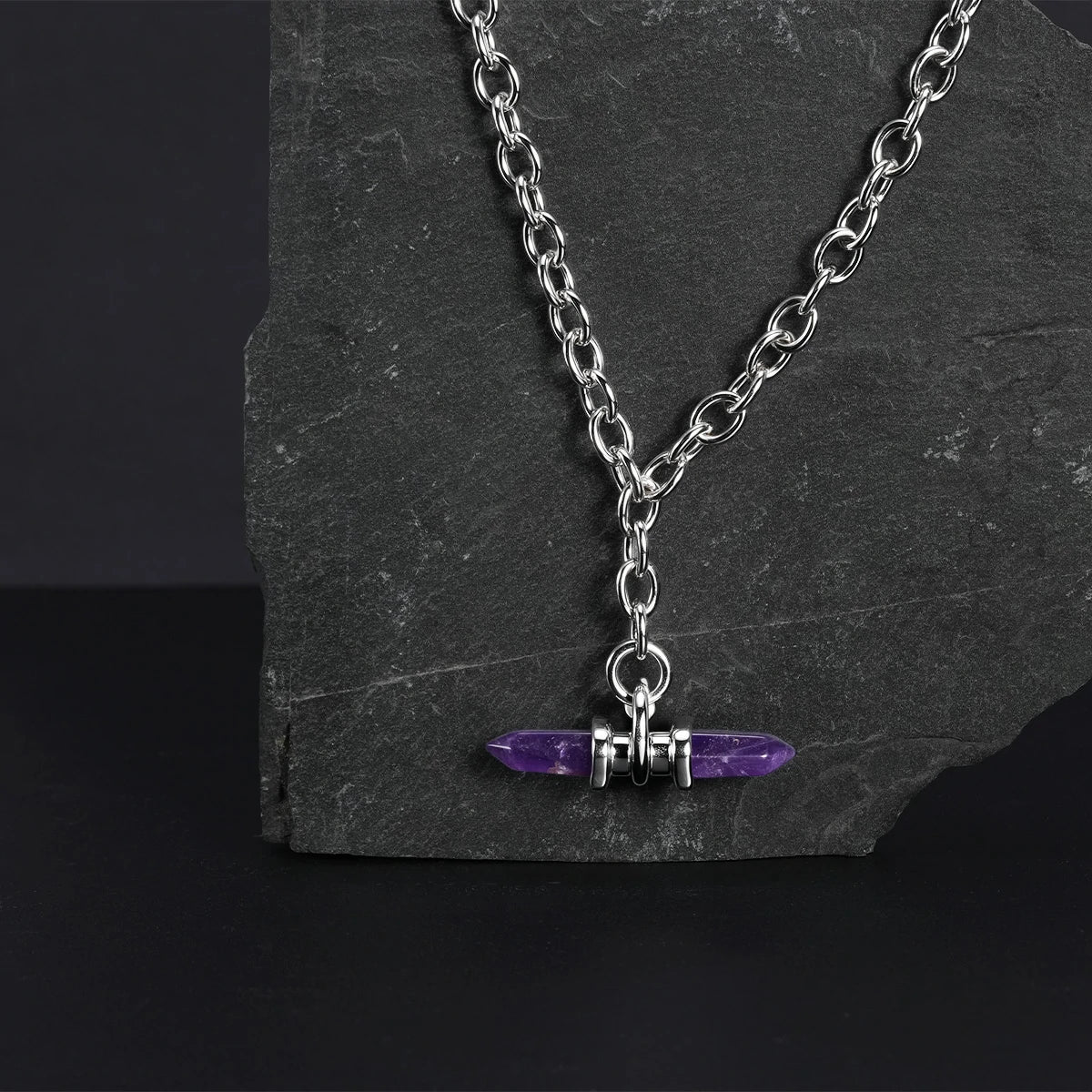 Silver Dual Prism necklace with purple pendant displayed on dark stone