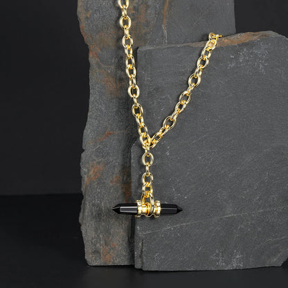Gold Dual Prism necklace with black pendant displayed on dark stone