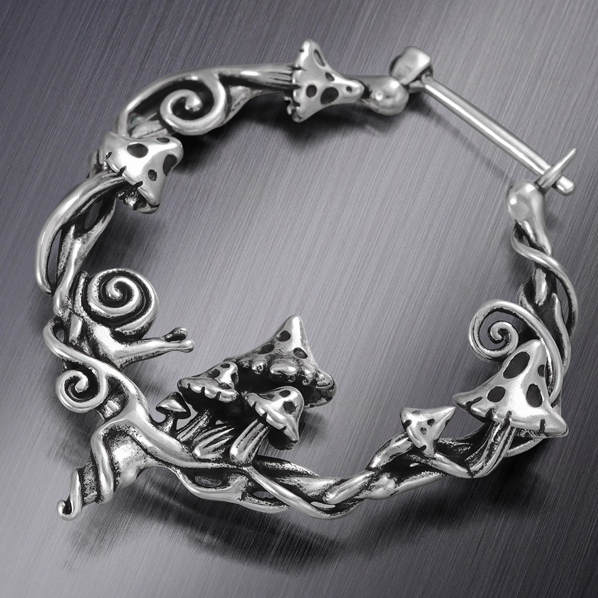 Close-up of silver Enchanted Forest Whimsy hoop earring with fox and vine details