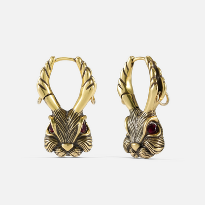 Pair of gold-tone jackalope hoop earrings featuring antler details and red gemstone eyes, front view