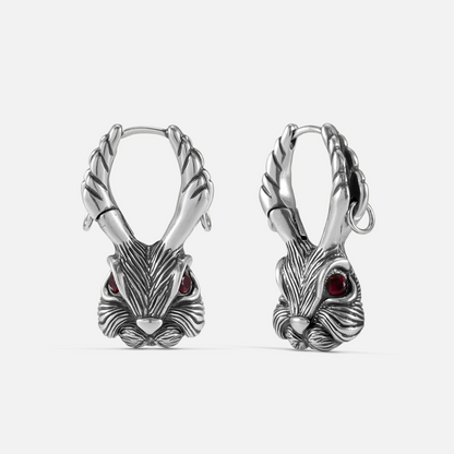 Pair of oxidized silver-tone jackalope hoop earrings with antlers and red gemstone eyes, front view