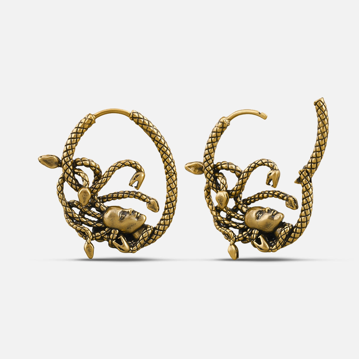 Pair of gold Enchanted Medusa hoop earrings with serpent-framed faces