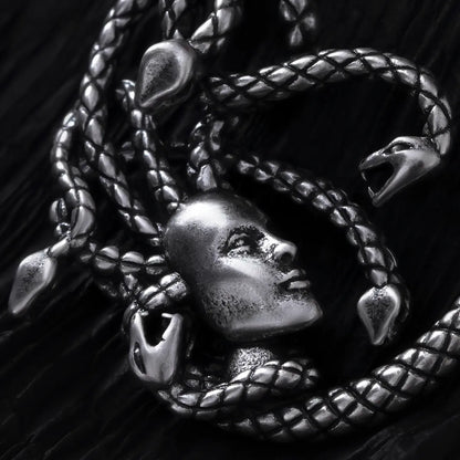 Close-up of silver Enchanted Medusa earring with face and serpent details