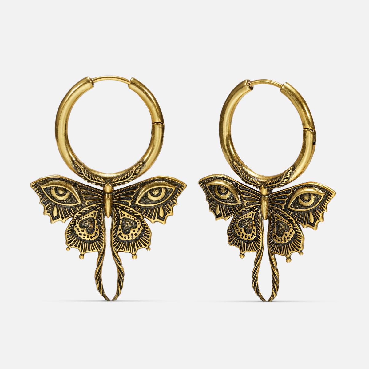 Pair of gold-tone Enchanted Moth hoop earrings with engraved wings, eye details, and long curled tails