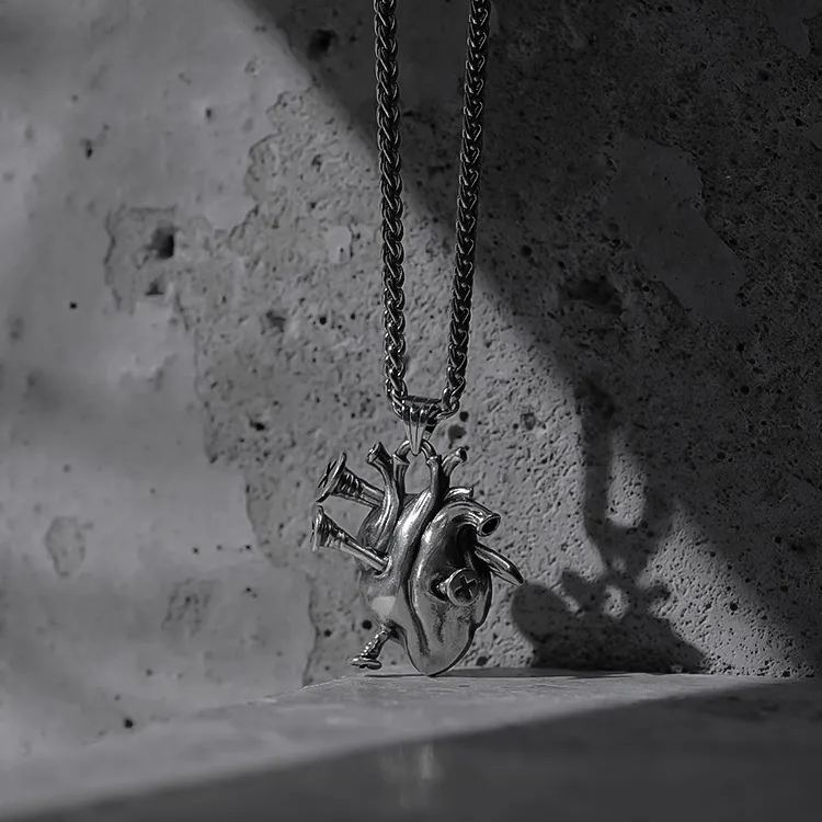 Silver Enduring Heart necklace with anatomical heart pendant on concrete
