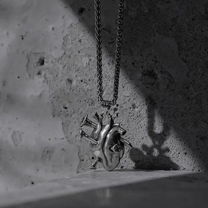 Silver Enduring Heart necklace with anatomical heart pendant on concrete