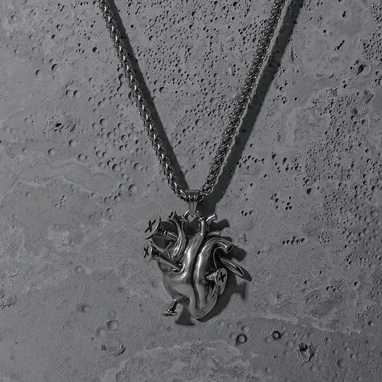 Silver Enduring Heart pendant necklace displayed on a textured surface
