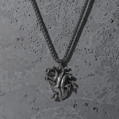 Silver Enduring Heart pendant necklace displayed on a textured surface