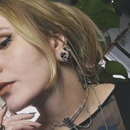 Close up of a blonde model wearing a coiled snake tunnel earring with layered necklace