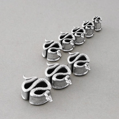 Enigmatic Serpent tunnels in graduated sizes arranged on a light surface