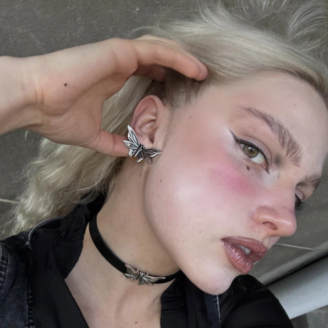 eternal moth ear studs worn by model in a close-up view, highlighting the silver moth design on the ear