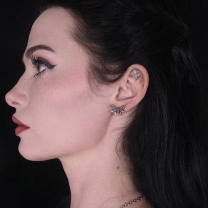 Model wearing a silver Eternal Moth ear stud on the earlobe