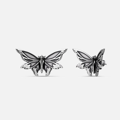 Pair of silver Eternal Moth ear studs shown from front and side angles