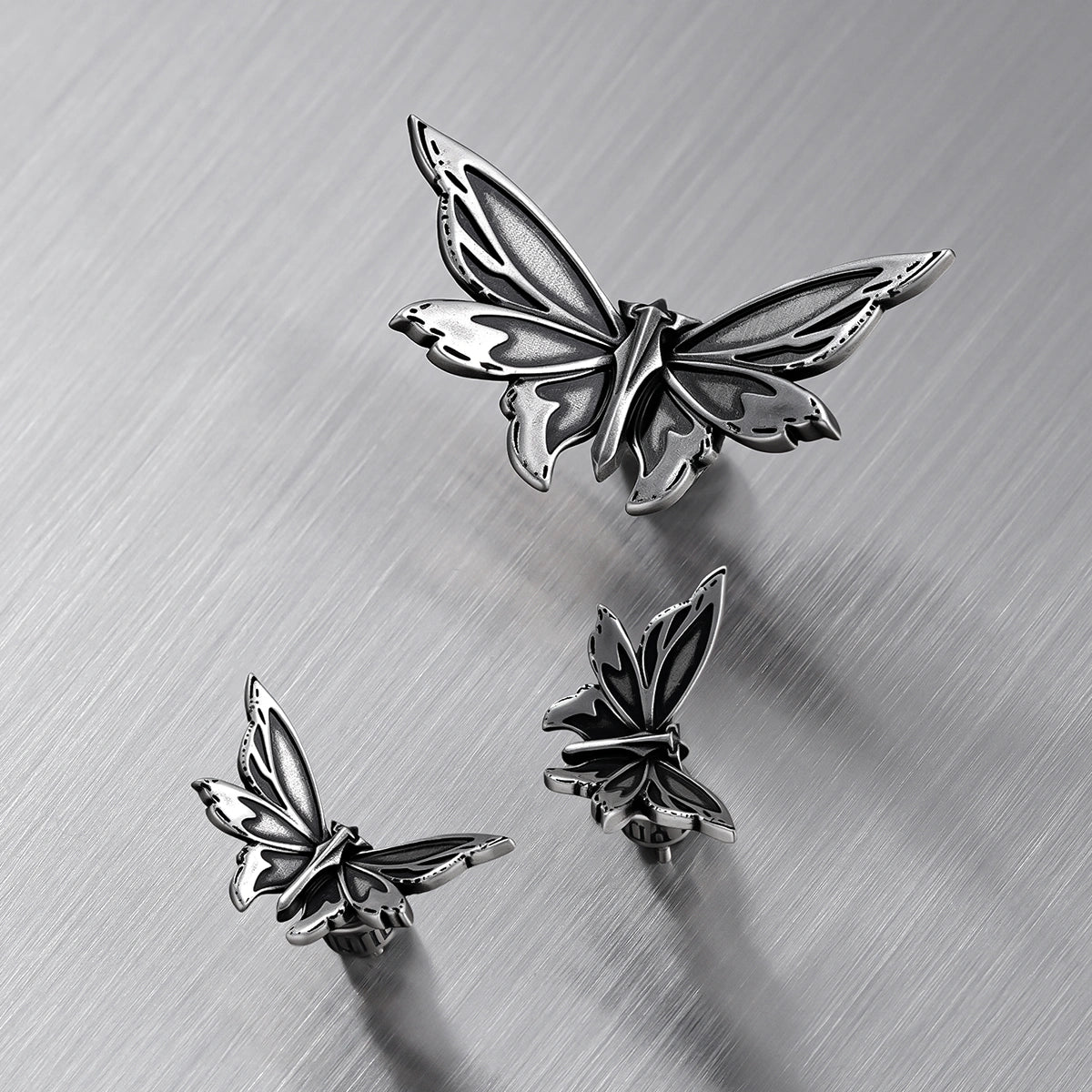 Silver Eternal Moth ear studs arranged in multiple front and side views