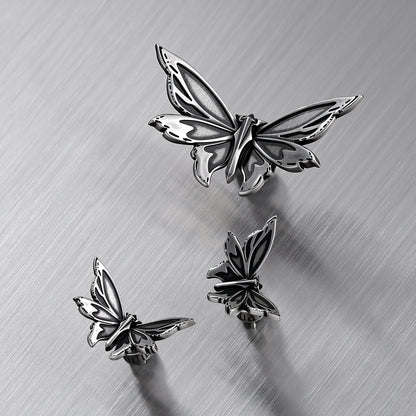 Silver Eternal Moth ear studs arranged in multiple front and side views