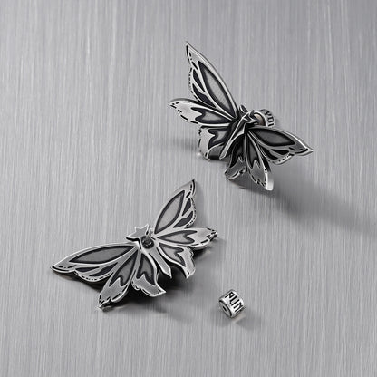 Pair of silver Eternal Moth ear studs with one removable backing visible