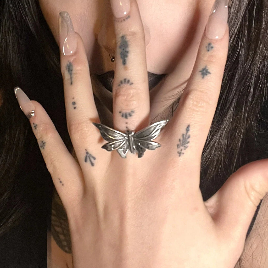 eternal moth rings shown in a model wear view, featuring a silver moth-shaped ring worn on the finger with a dark gothic beauty look
