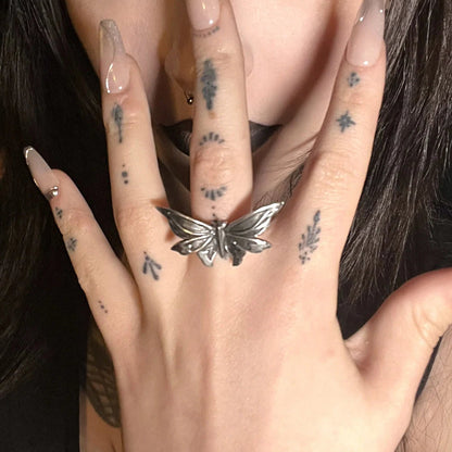 eternal moth rings shown in a model wear view, featuring a silver moth-shaped ring worn on the finger with a dark gothic beauty look