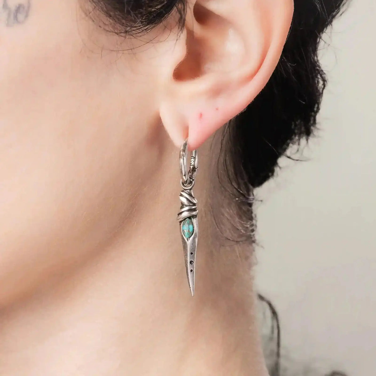 Eye Dagger Earrings in 925 sterling silver, worn in a close ear view, showing the turquoise eye-shaped inlay and long dagger 