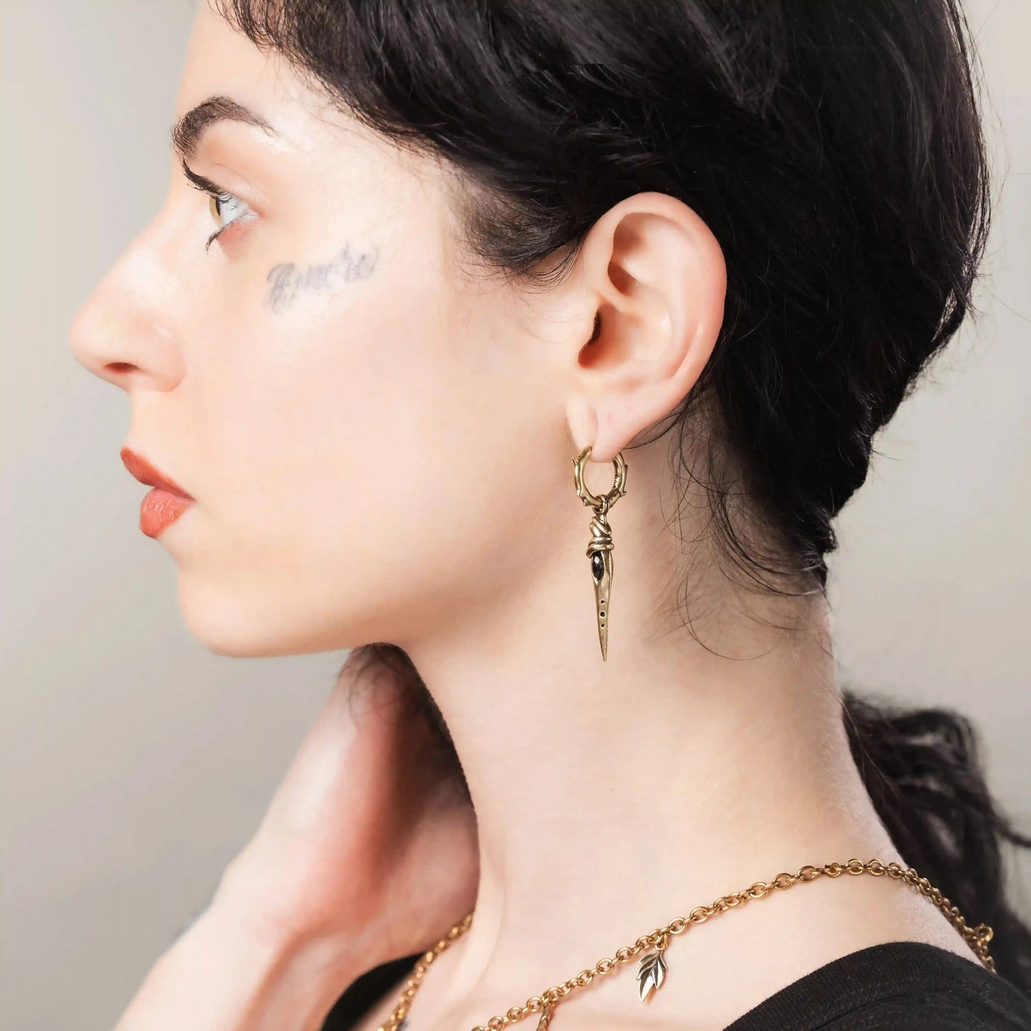 Gold Eye Dagger Earrings styled on model with talisman-inspired eye detail and antiqued finish