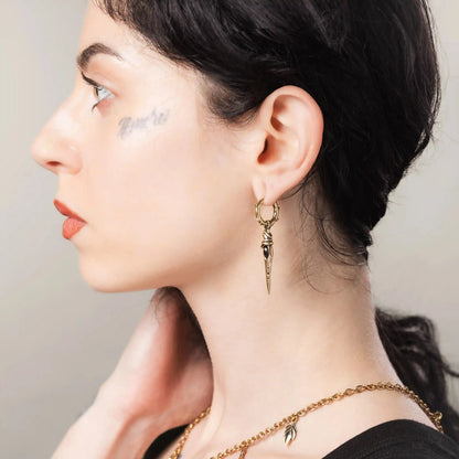 Gold Eye Dagger Earrings styled on model with talisman-inspired eye detail and antiqued finish