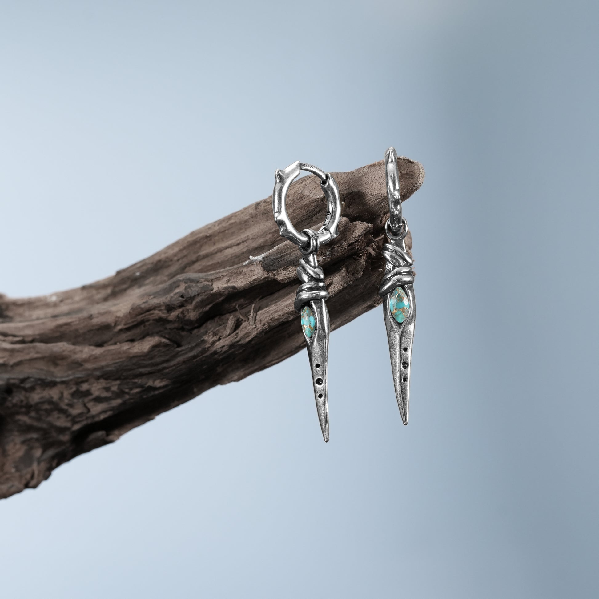 Silver Eye Dagger Earrings displayed on weathered wood with eye stone inlay and dagger silhouette