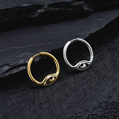Gold and silver-tone Eyelock hoop earrings resting side by side on a textured black surface
